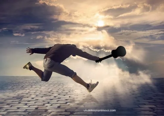 Man jumping with ukulele in hand.