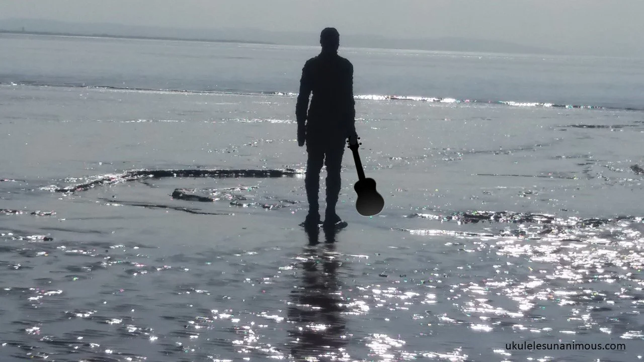Man standing in sea with ukulele.
