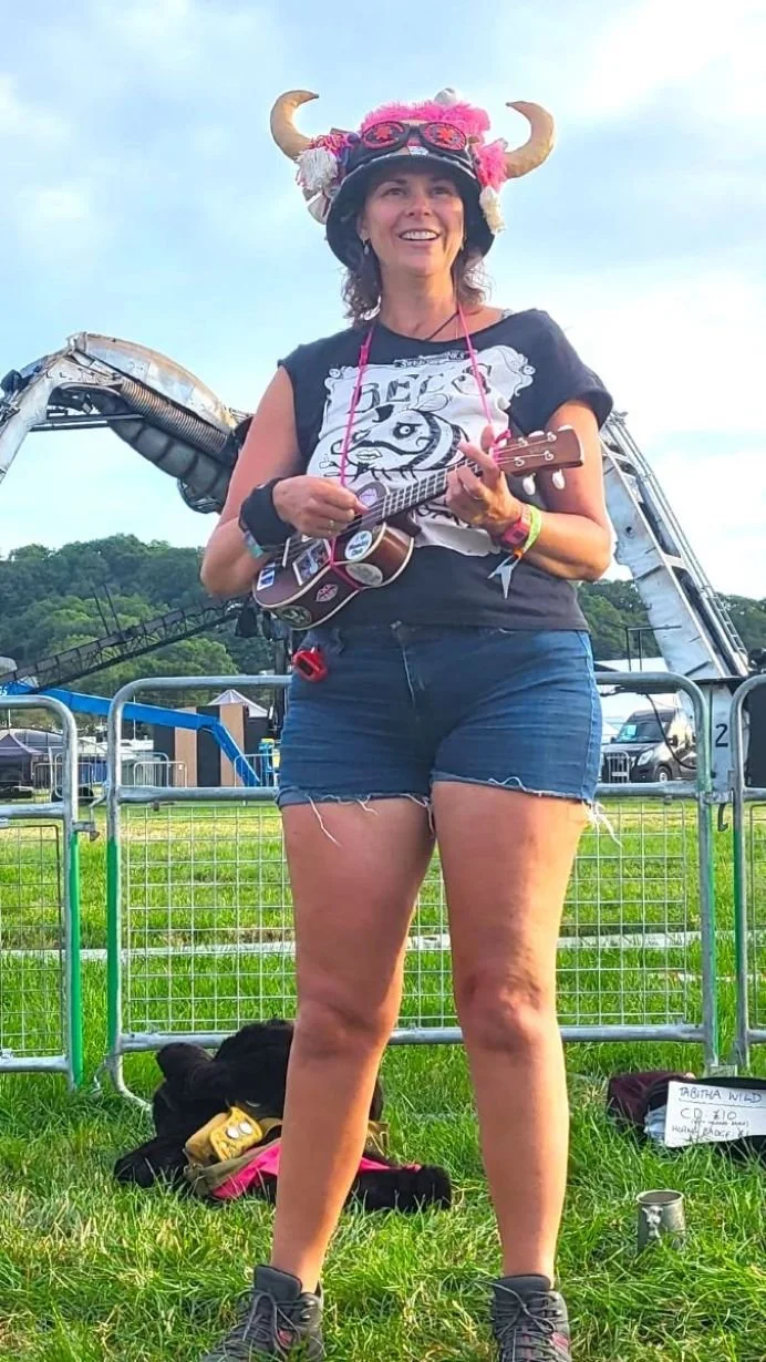 Lady playing ukulele at music festival.