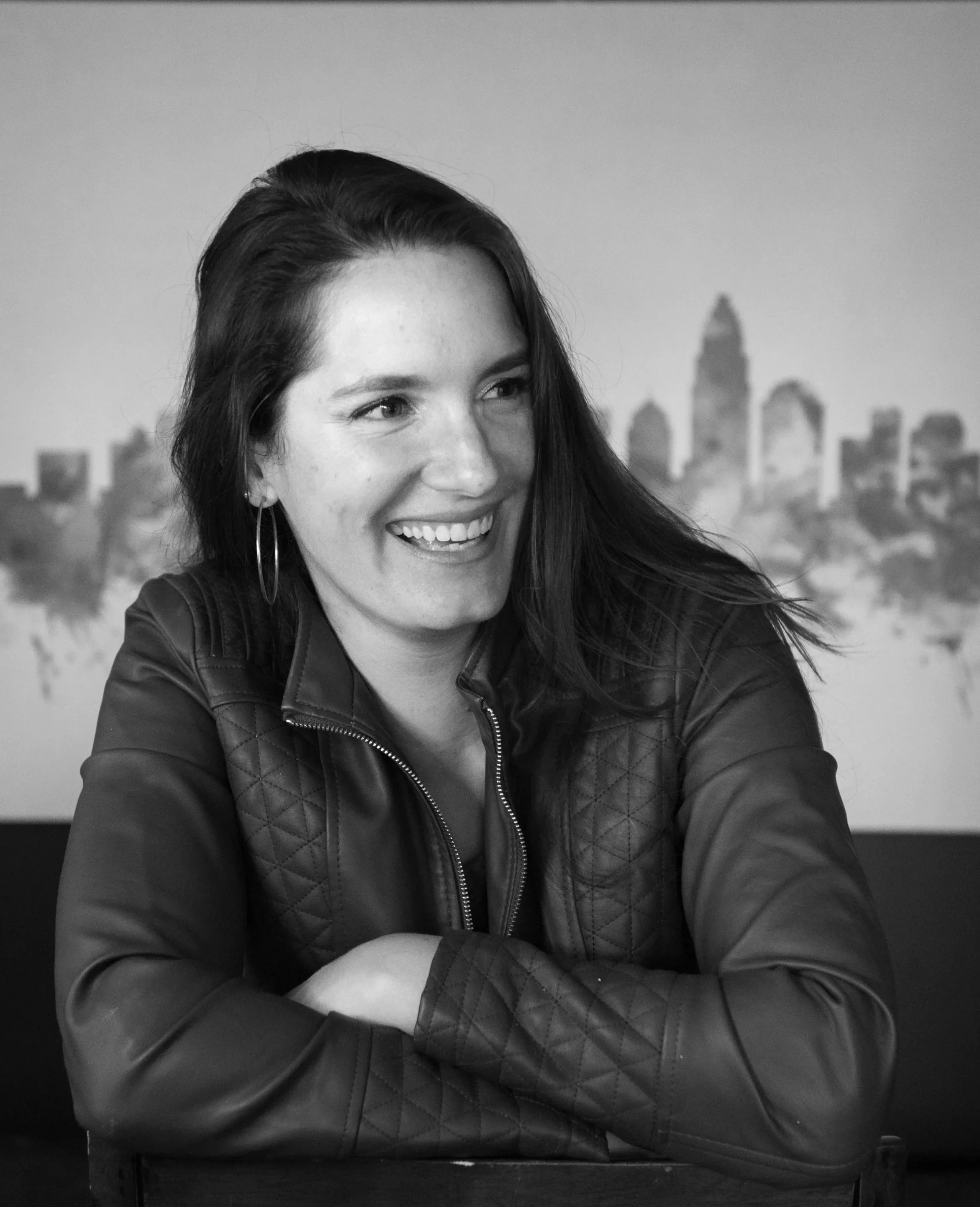 Headshot of Leslie Cramer, Keynote Speaker, with her arm folded and laughing.