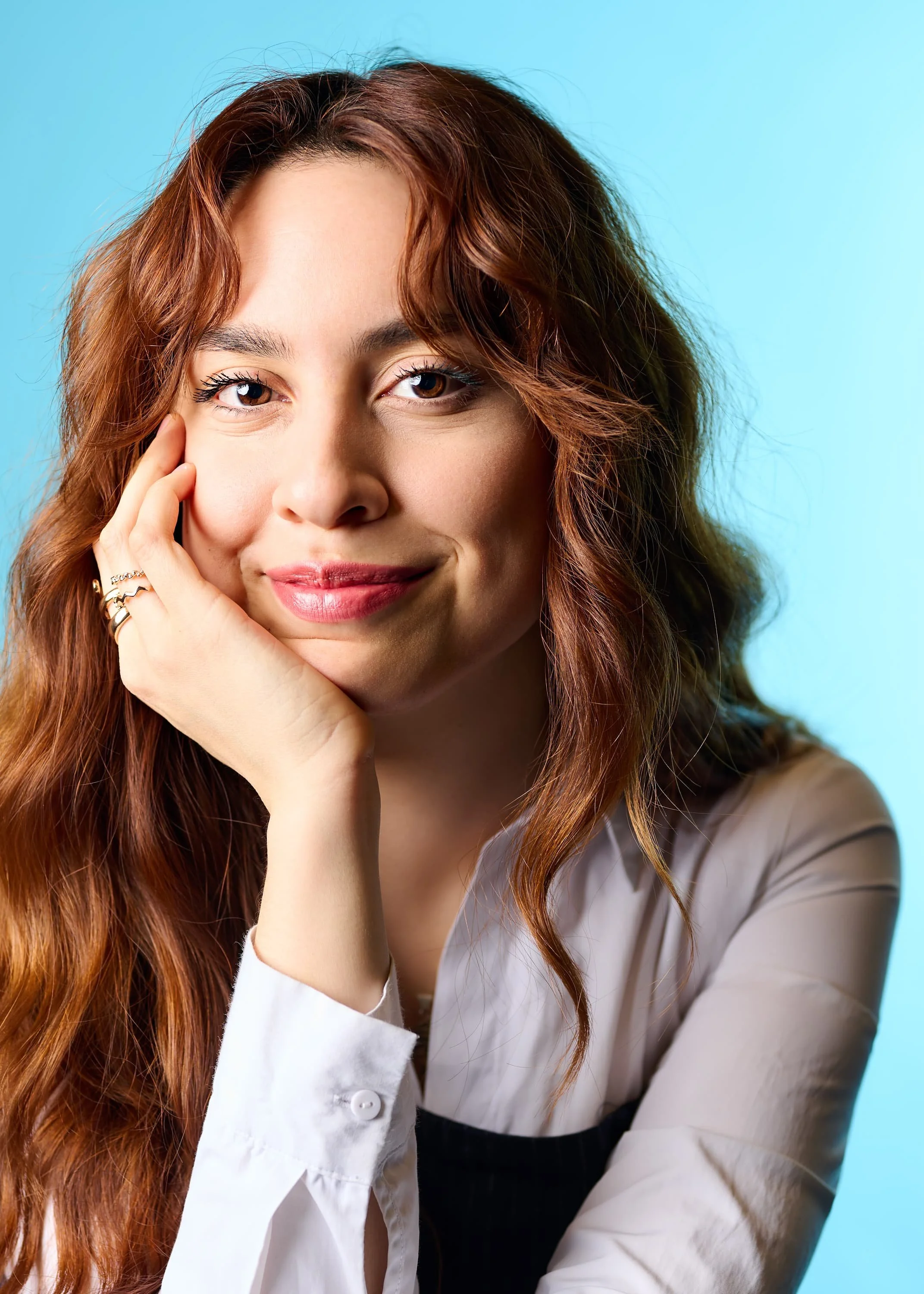 Colour portrait of a woman with her head resting on her hand looking into the camera
