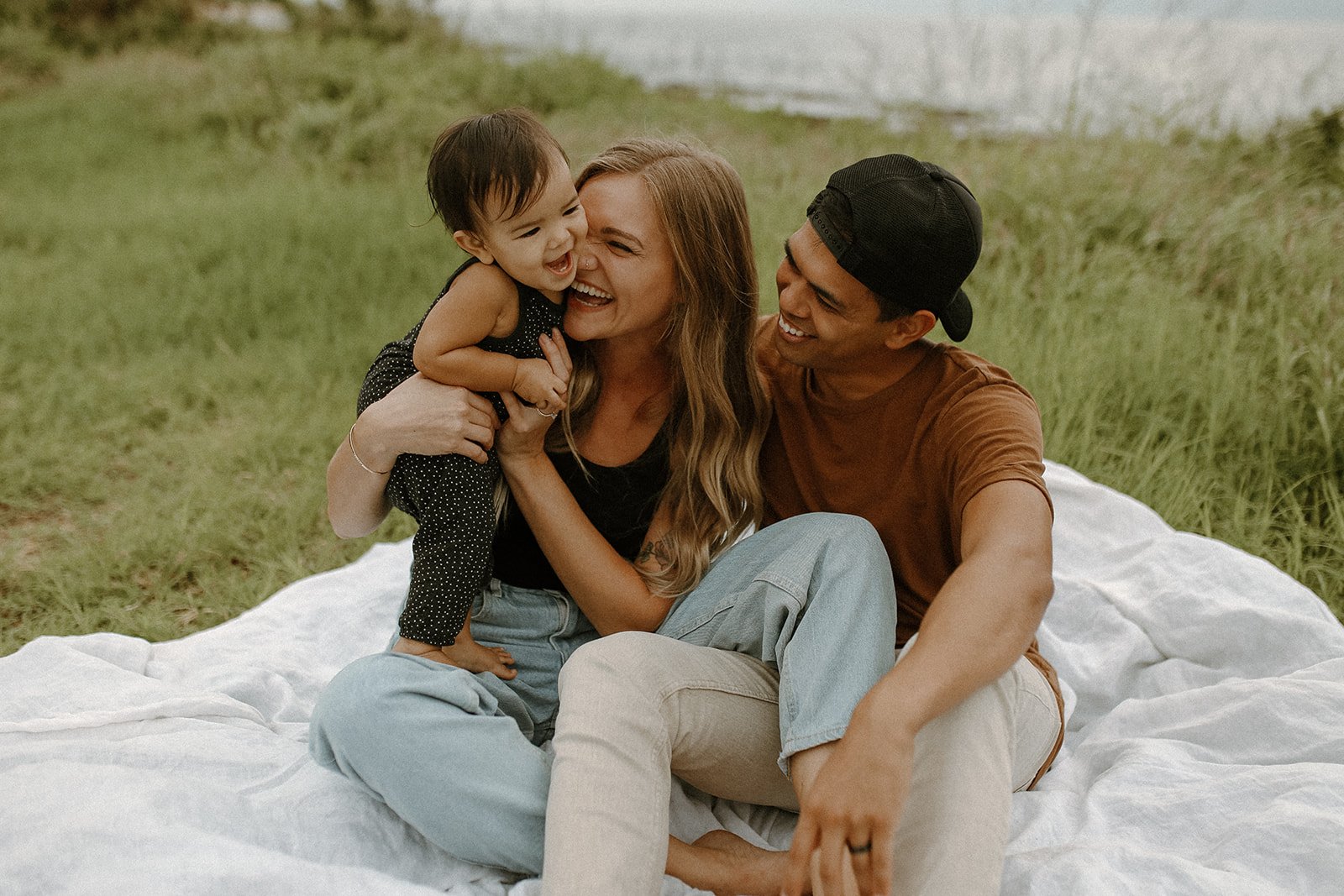 Hayley and Christian with their toddler at Makua Beach in Oahu, Hawaii