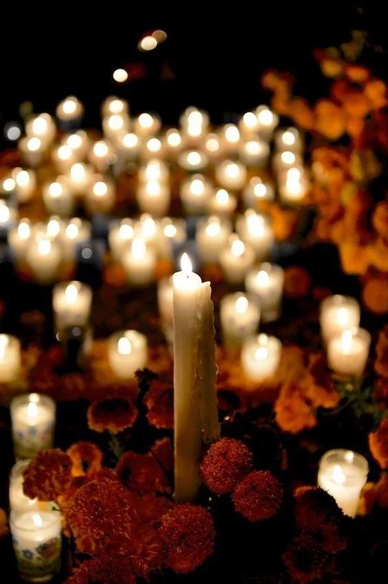 Candles around an ofrenda represent hope and are believed to guide souls between worlds