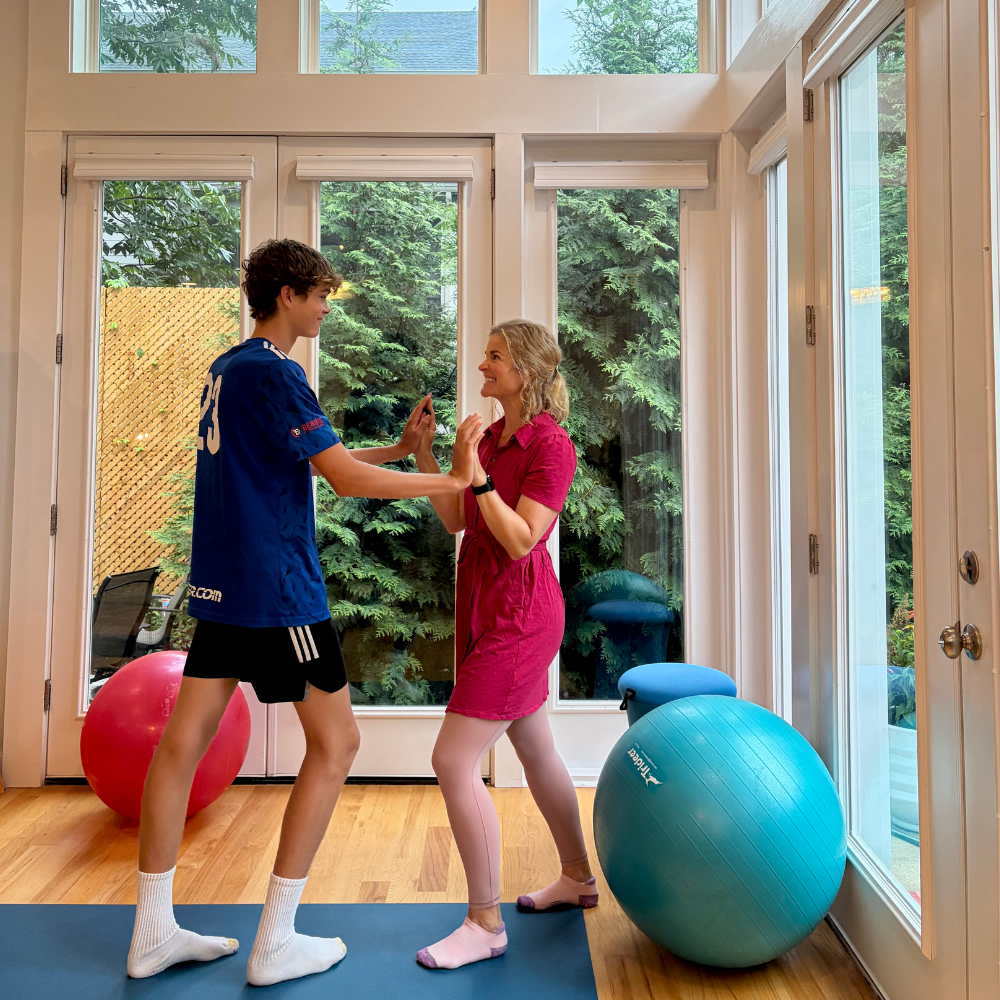 Teen practicing a supported Push somatic movement with parent