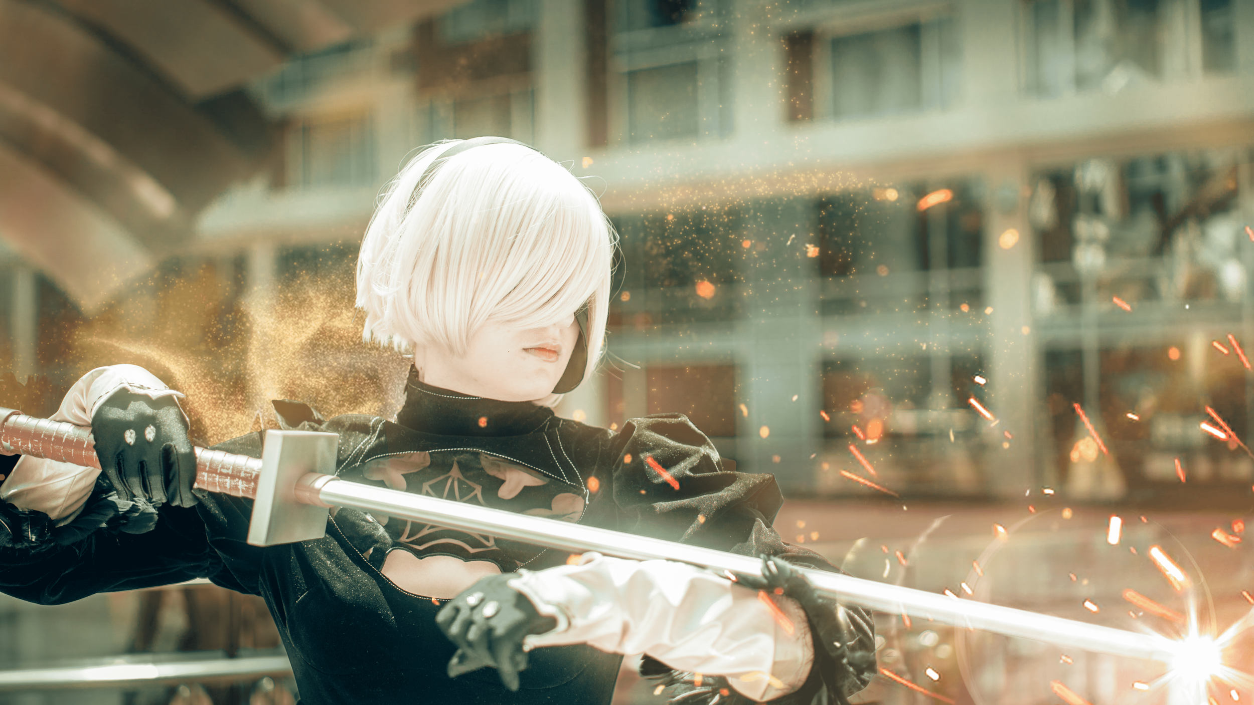 A person with short, platinum blonde hair wearing black armor and gloves, wielding a glowing sword, with sparks flying around in an urban environment.