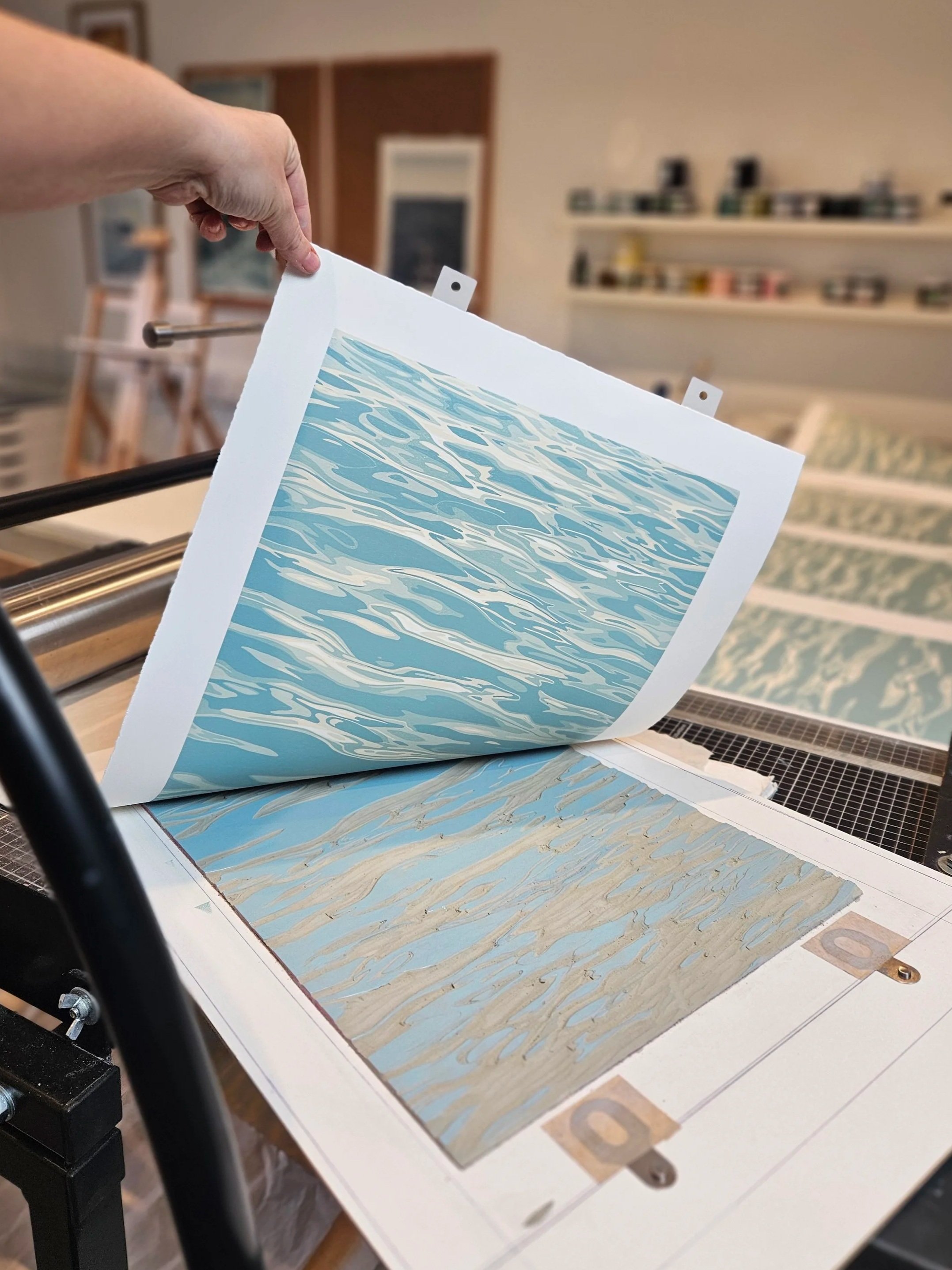 Traditional printmaker Megan Hall pulling a reduction print which is half way through the process.