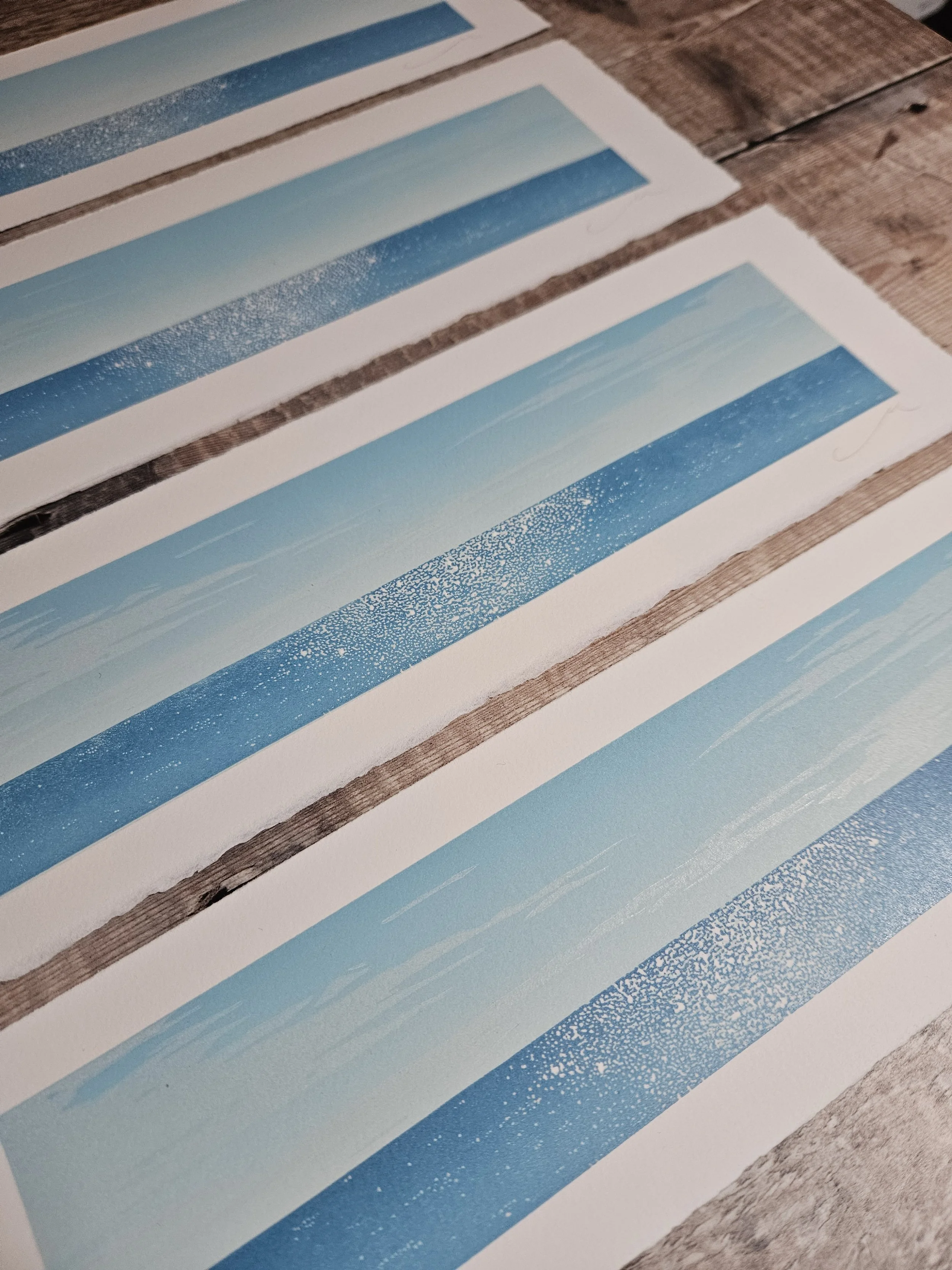 Multiple rectangular linocut prints of the horizon by artist Megan Hall