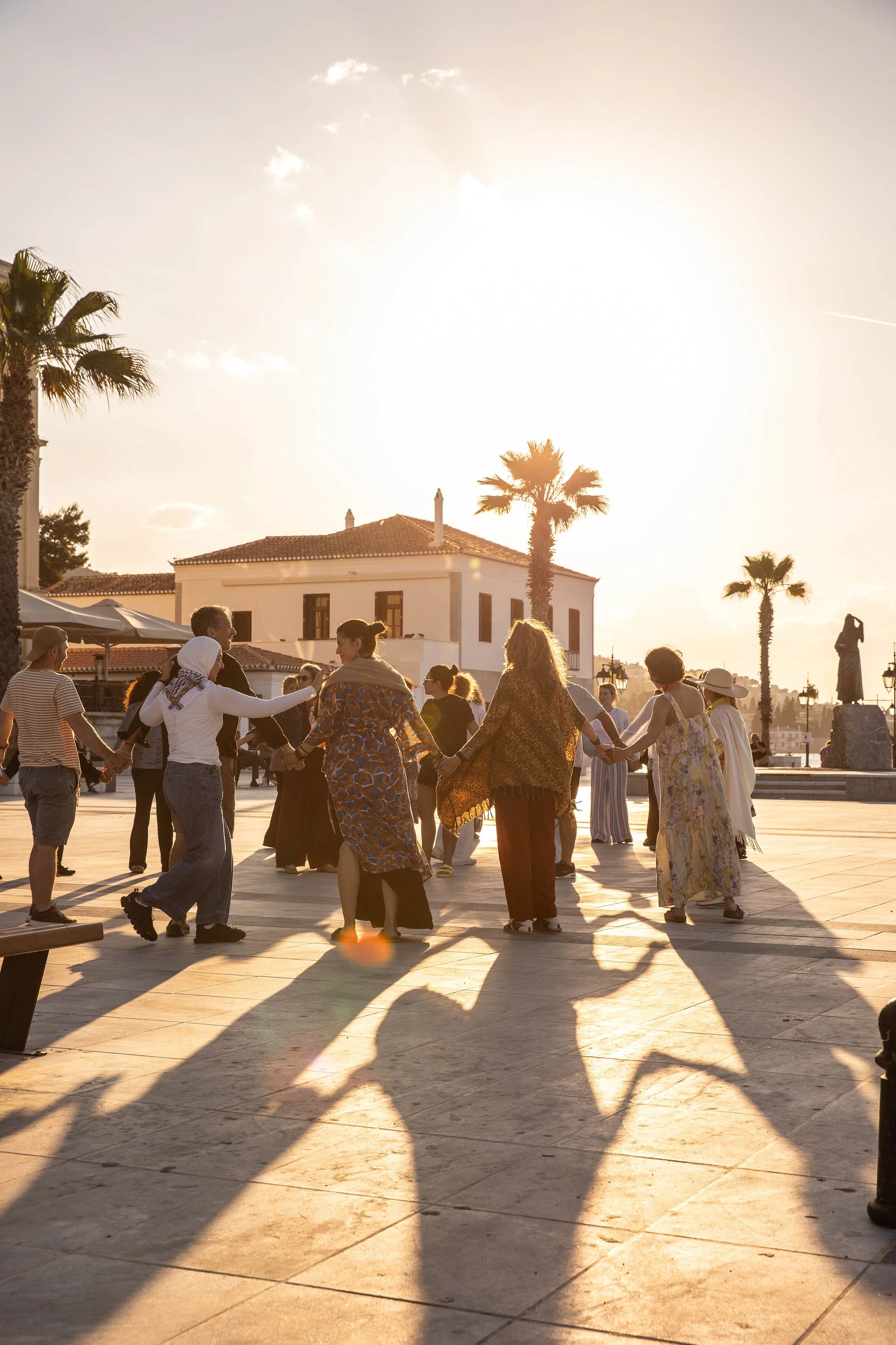 People standing in a circle at sunset