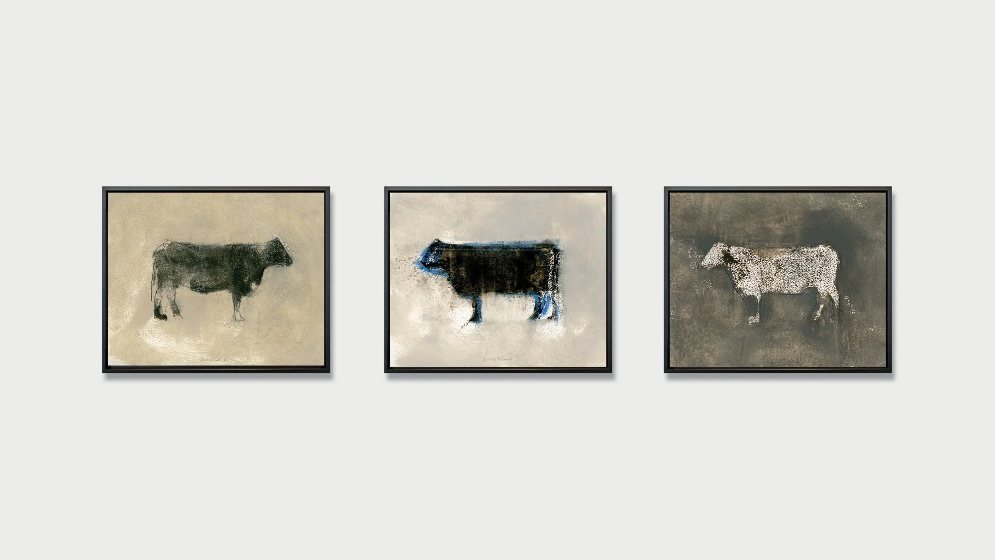 Three paintings of cows on a gallery wall.