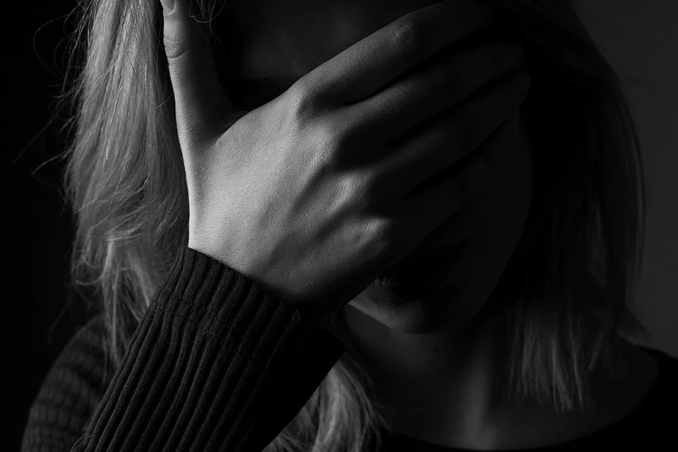 Woman with hand over face