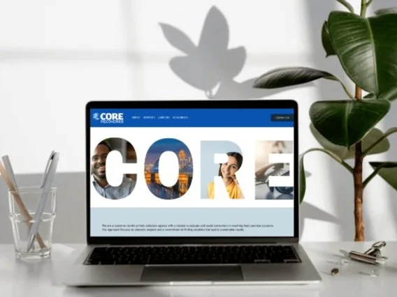 Laptop on a desk with "CORE" website displayed, showing diverse people and cityscape letters.
