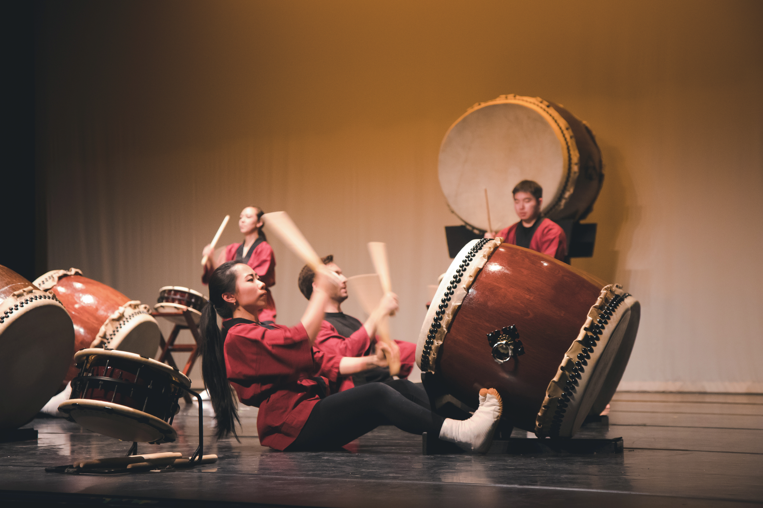 Group of performers playing traditional Japanese drums on stage.