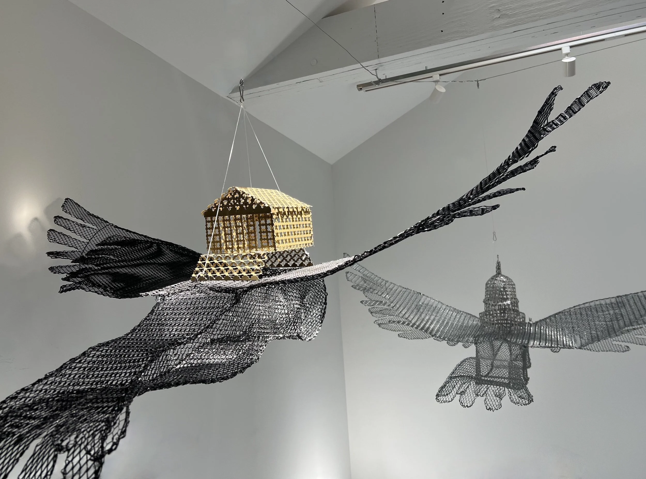 Suspended Monuments: Justice Deferred, 2026, wire, enamel, steel and aluminum mesh, 10' x 3' installation (31” x 54” x 15”, each of two)