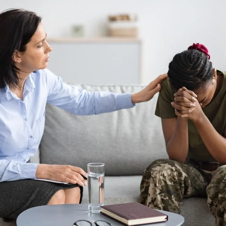Counselor comforting upset woman with hand on shoulder