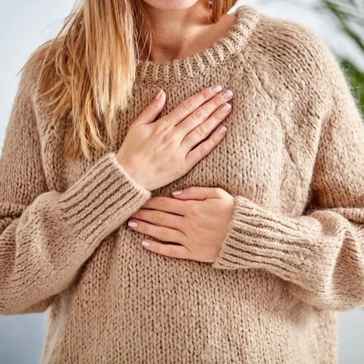 Woman placing both hands over chest, practicing grounding technique for calm