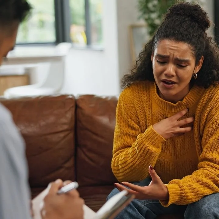 Woman expressing emotions during CBT session focused on reducing OCD intrusive thoughts.