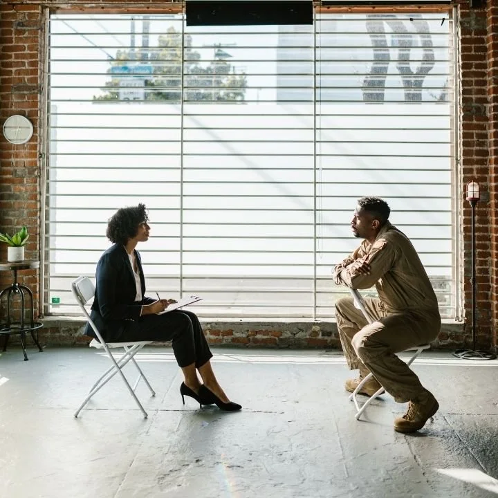 Trauma therapist and patient engaged in an evidence-based counseling session in a private therapy office.