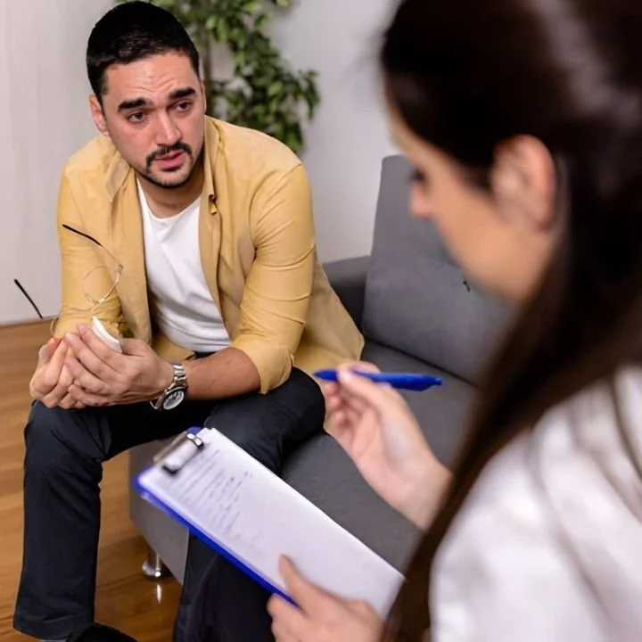 Man discussing trauma with a therapist during an EMDR therapy consultation.