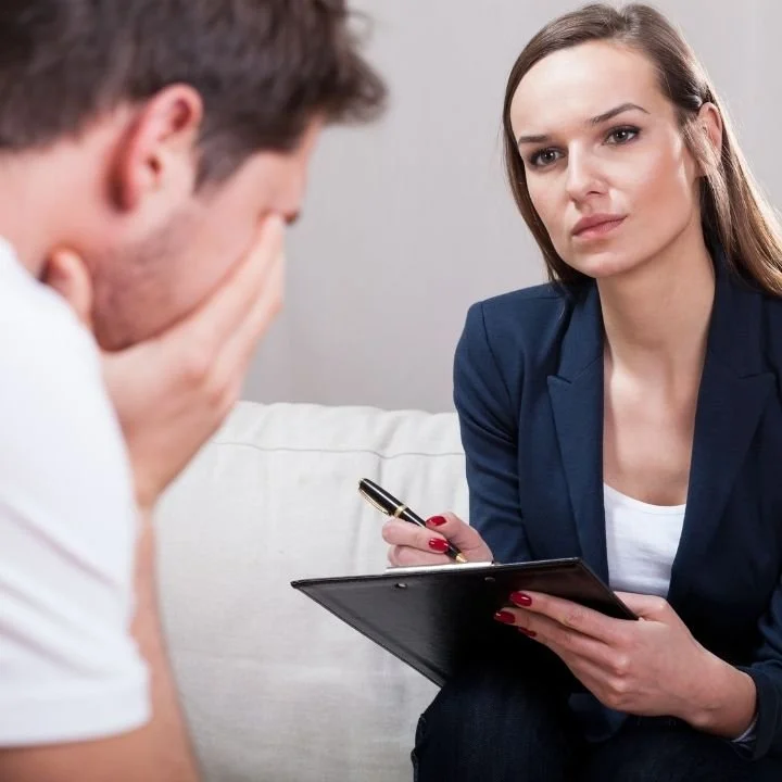 Female counselor listening to distressed male client during discussion