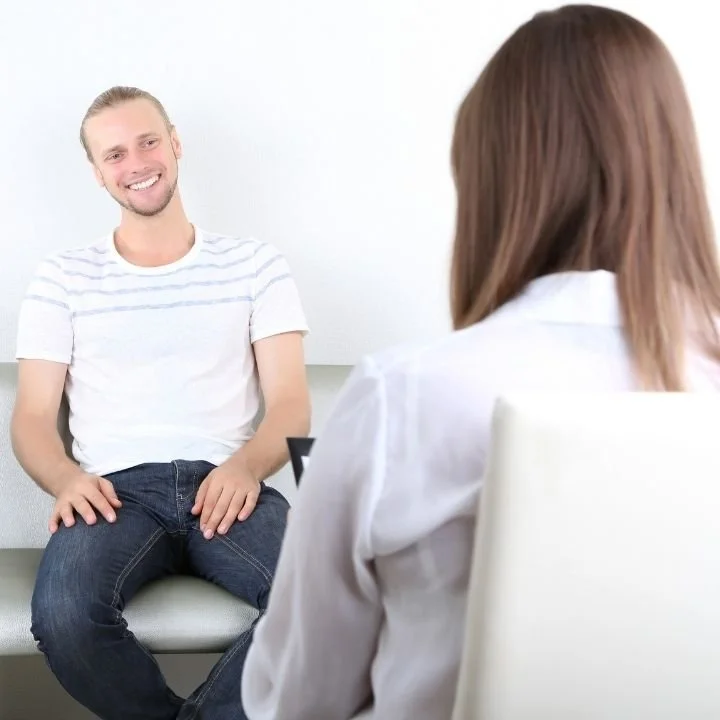 Client smiling during CBT therapy after making progress managing OCD intrusive thoughts.