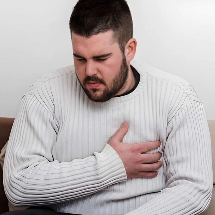 Man clutching chest during intense panic episode.