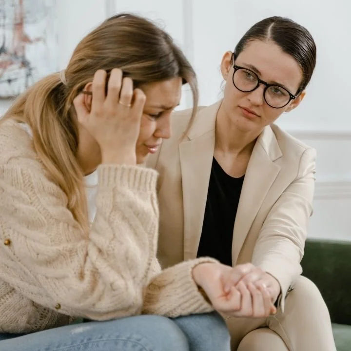 Therapist offering support to a distressed woman during a counseling session.