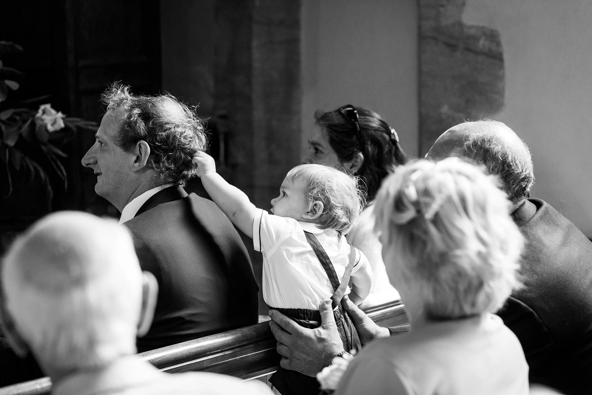 Candid photo of wedding guest and a child during wedding service, Carlos Azevedo Photography