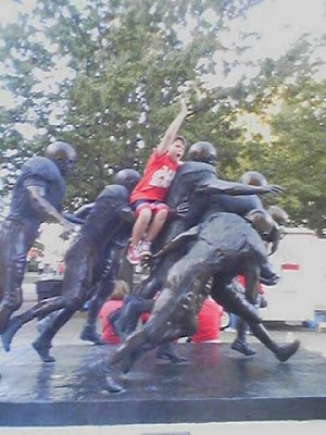 Grant reenacts 'the play' on the statue that adorns the entrance to the East Stadium.&nbsp;One of my favorites.&nbsp; Note the red shoes!!