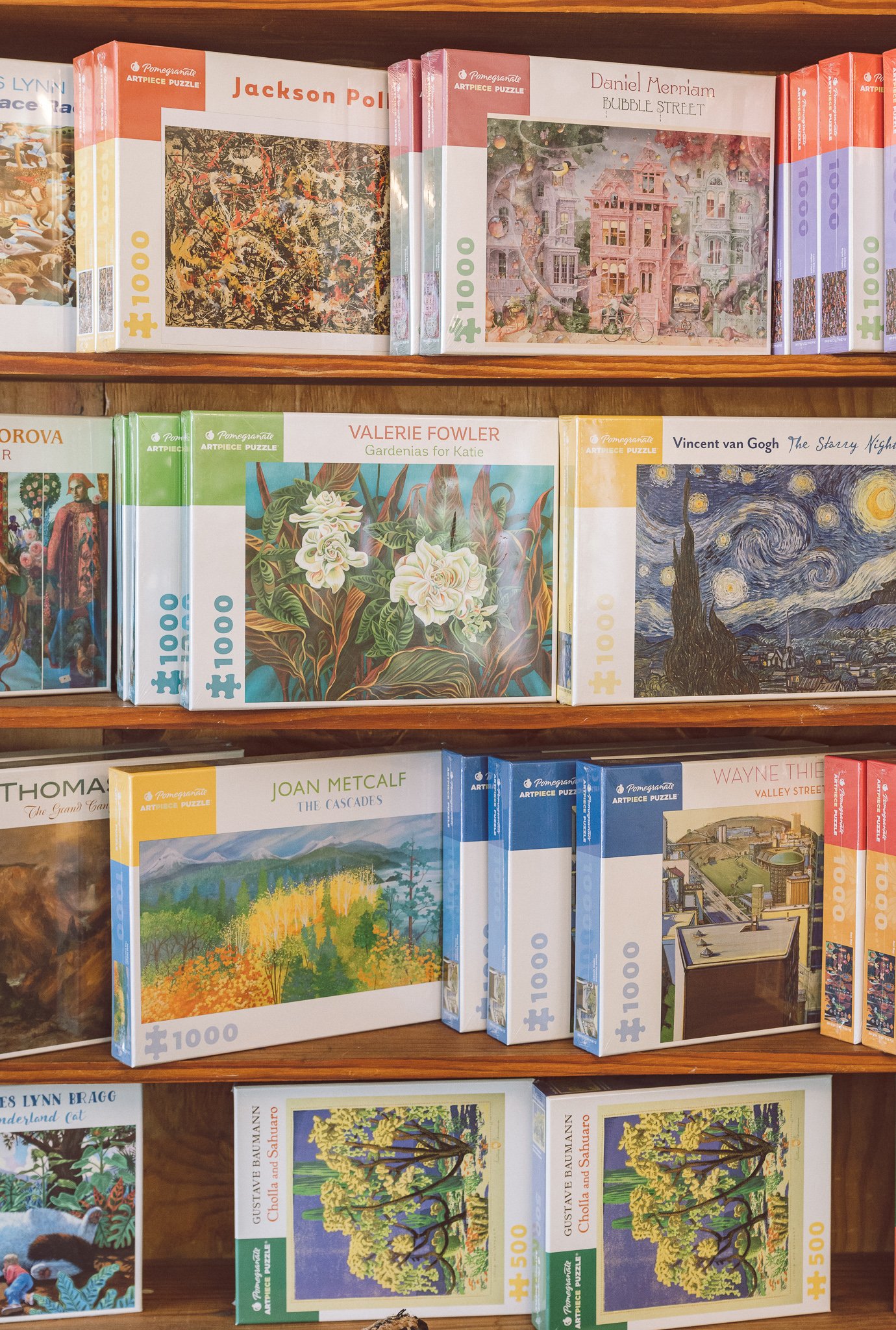 Assorted art-themed jigsaw puzzles on shelves
