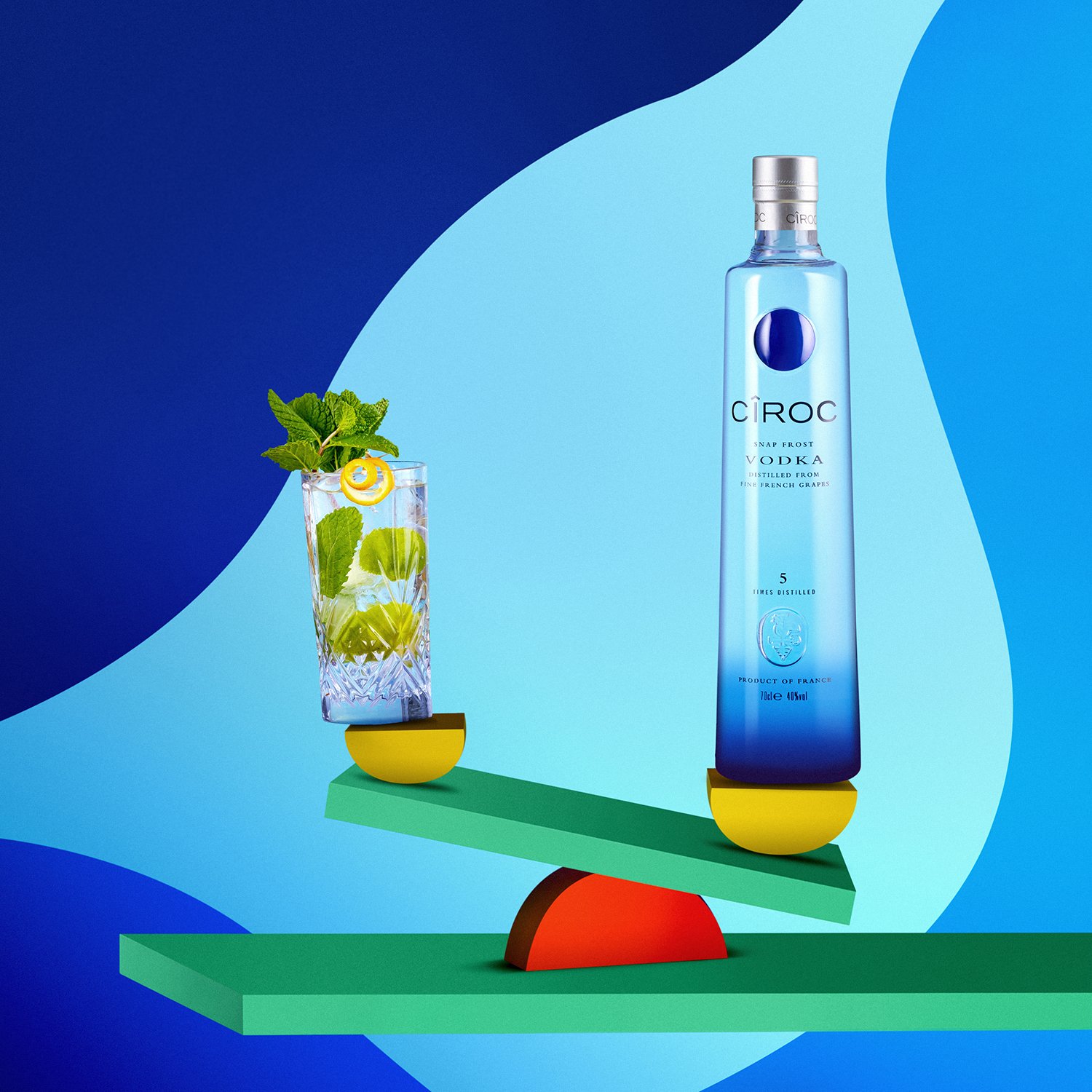 Bouteille de vodka Cîroc et verre à cocktail avec menthe et citron, fond bleu artistique.