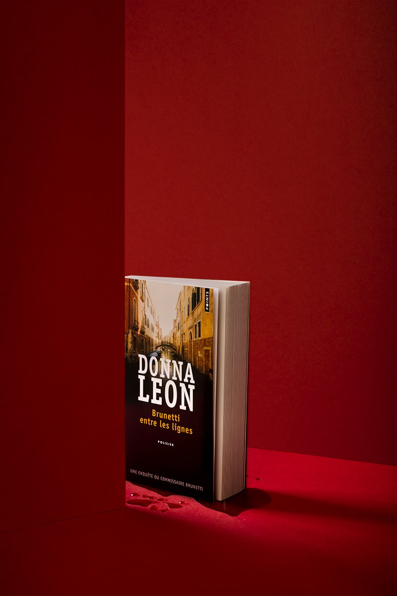 Livre "Brunetti entre les lignes" par Donna Leon sur fond rouge.