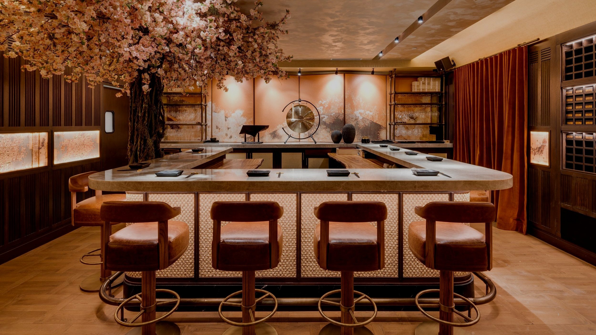 Japanese inspired interior design of MILA Omakase dining experience with a cherry blossom tree, and a gong.