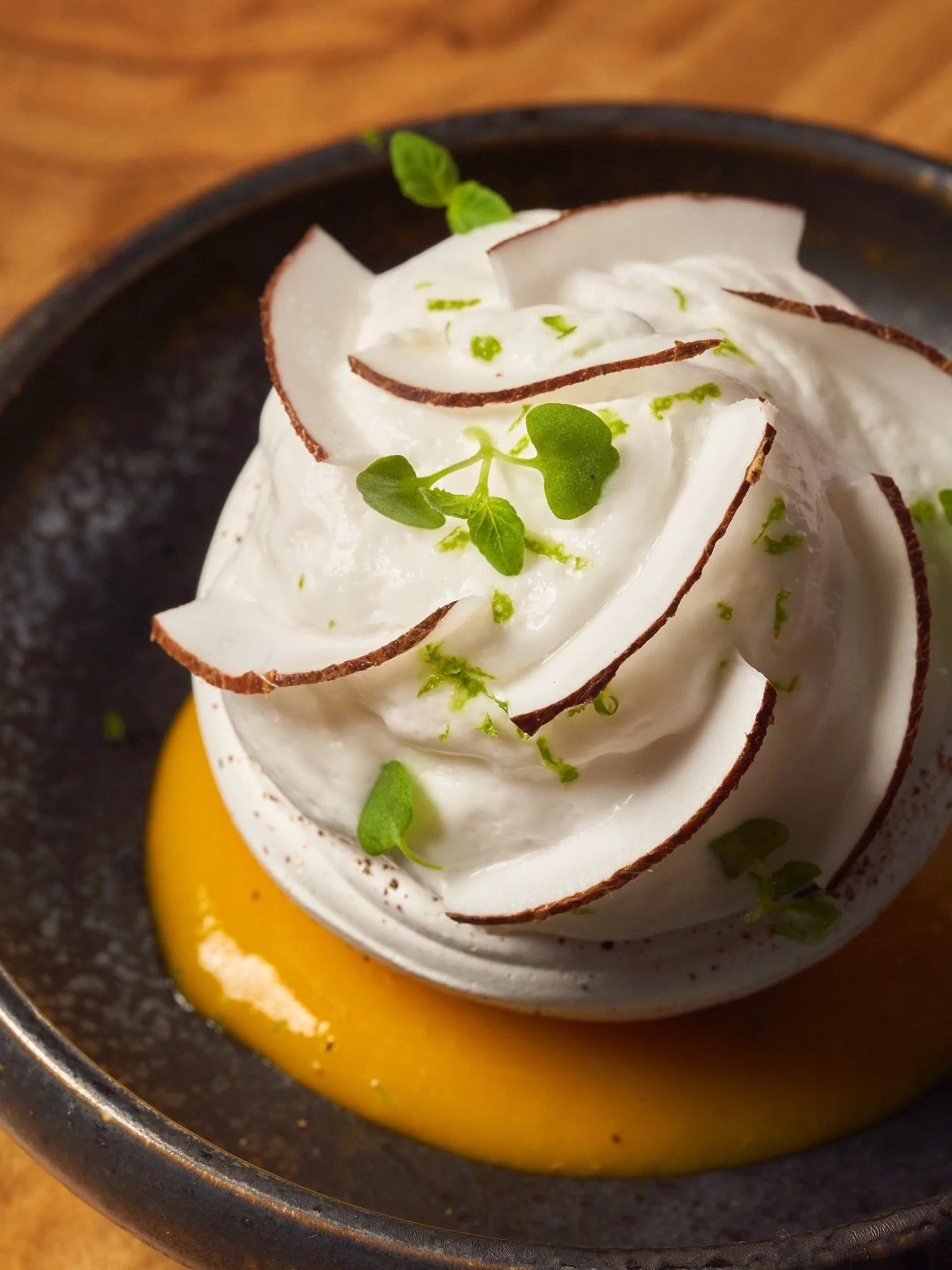 Uncover a delicate balance of tropical flavors with our Exotic Vacherin. Crafted with coconut espuma, passion fruit-mango coulis, and paired with vanilla cream this dessert makes for a light and refreshing conclusion to your dining experience at MILA