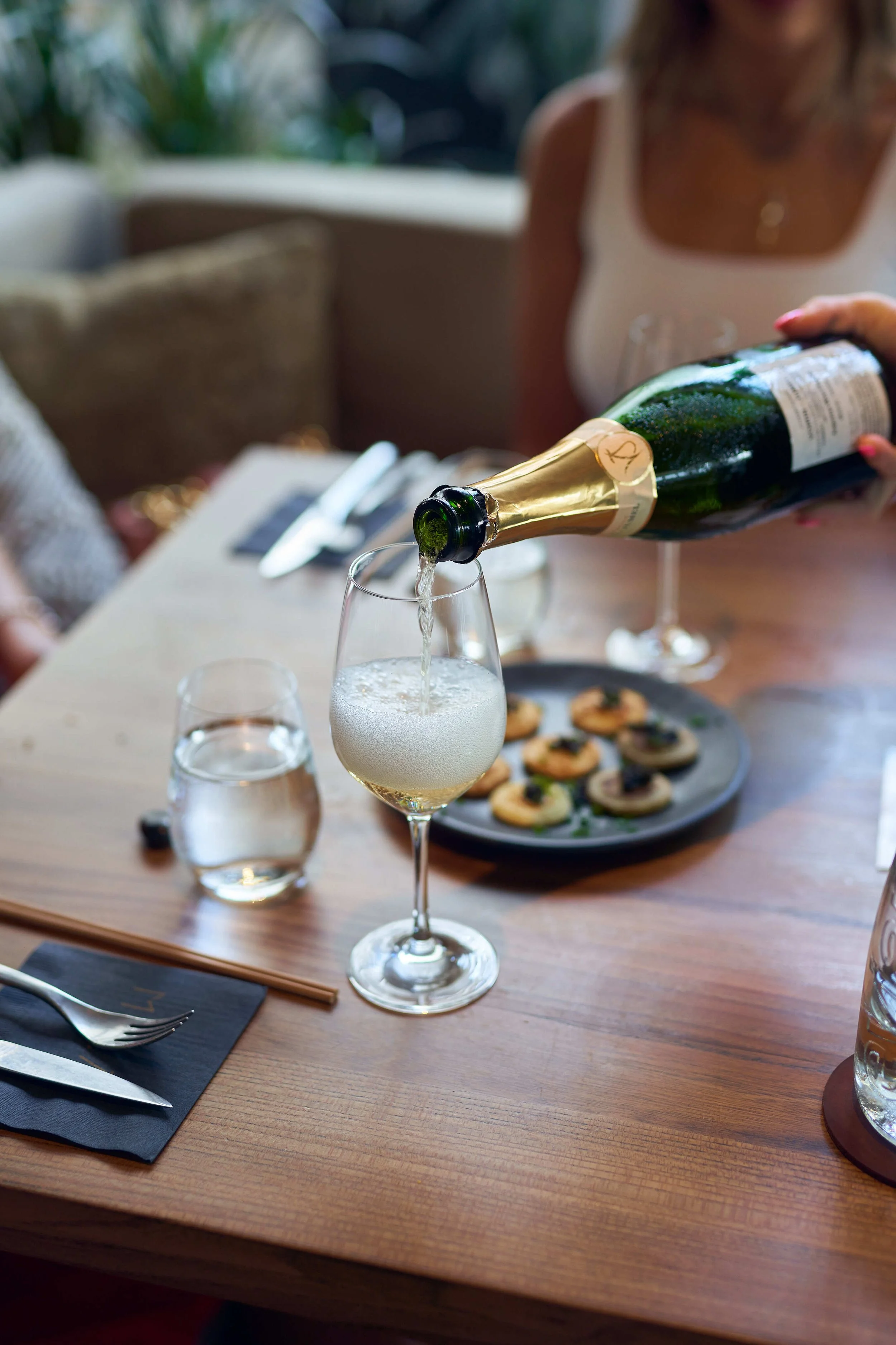 A guest at the MILA brunch experience getting poured chamapgne, apart of the beverage package.
