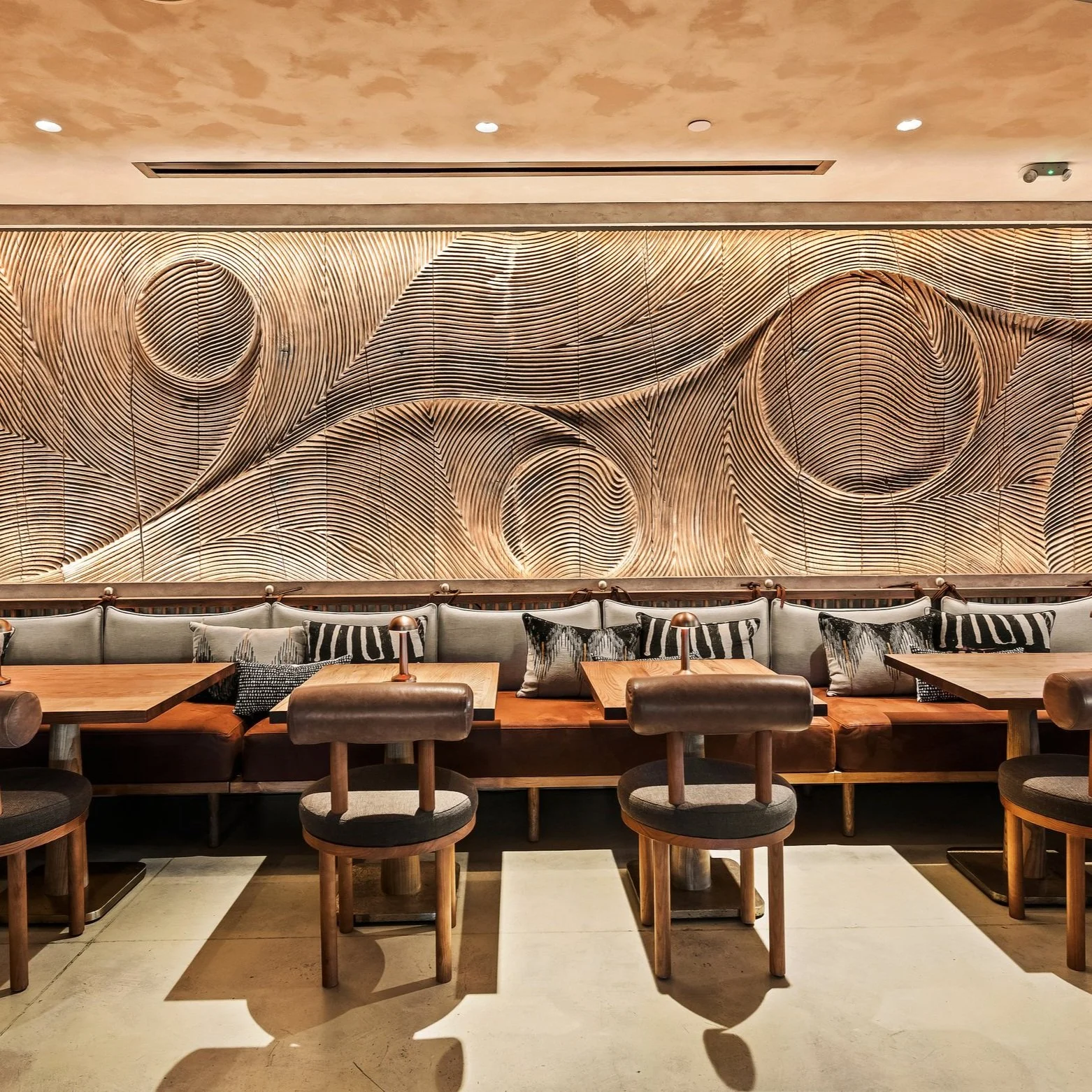 A minimalistic design of the interior setting of MILA Miami restaurant. with artwork on the walls.