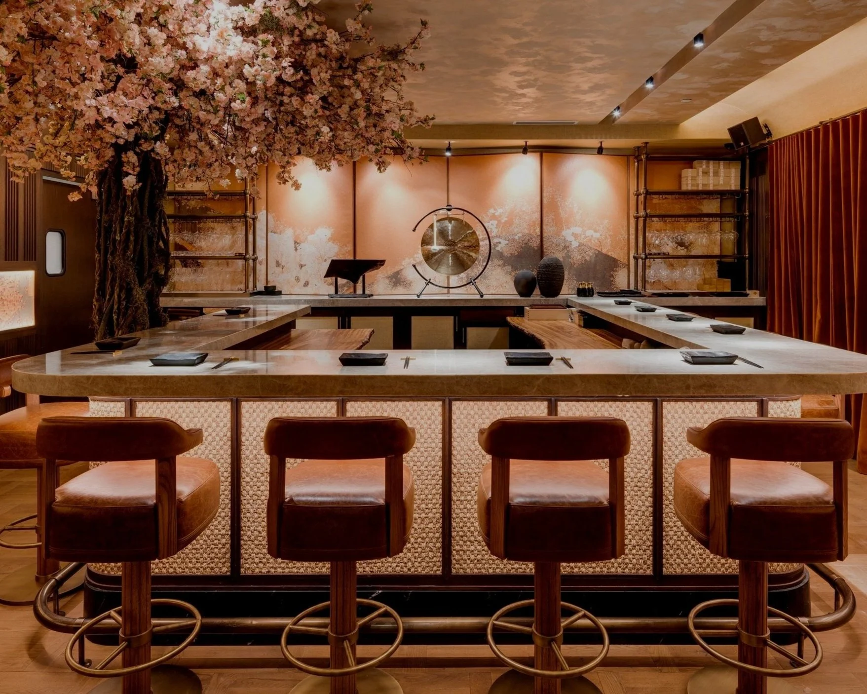MILA Omakase dining space with chairs lining the outside and a japanese cherry blossom tree on the left