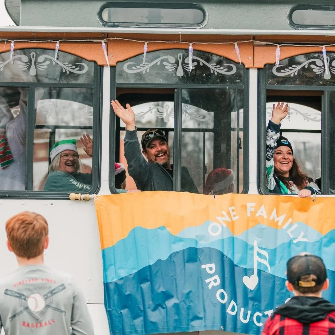 people wave from a trolley car