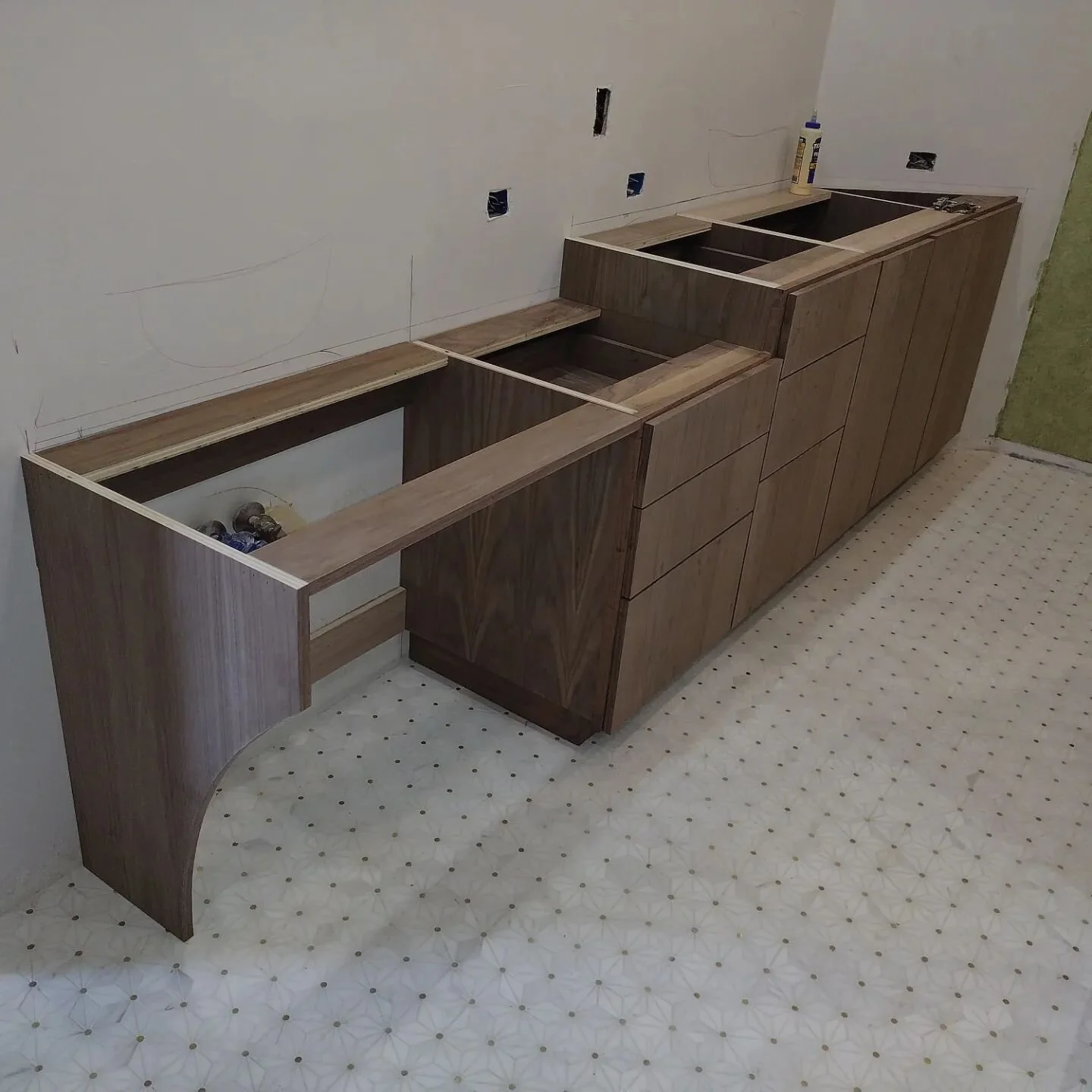 It's great when you're on vacation and a work buddy sends you progress pictures of a project you are in charge of. I left before we got the drawer fronts and doors finished. These custom walnut cabinets still aren't finished but they are coming along