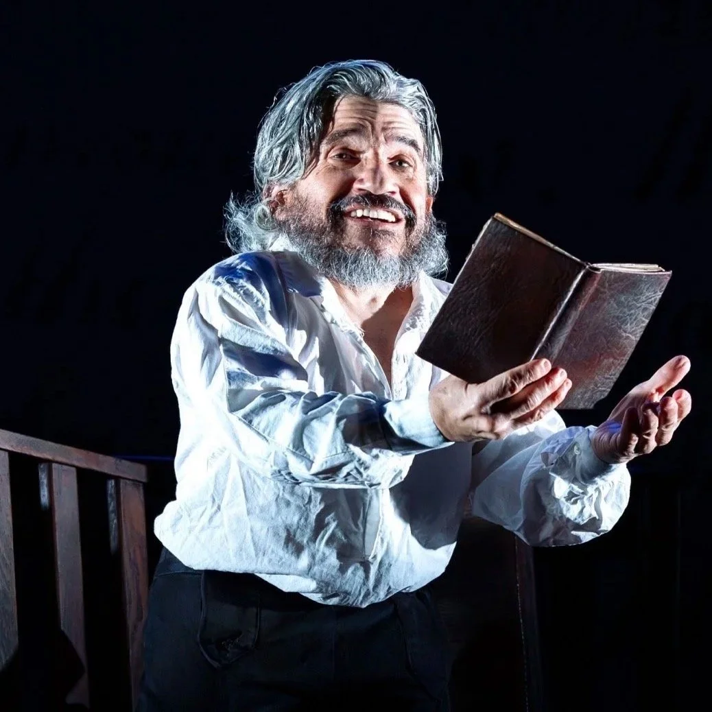 Actor portraying Benjamin Lay holding an open book during the performance