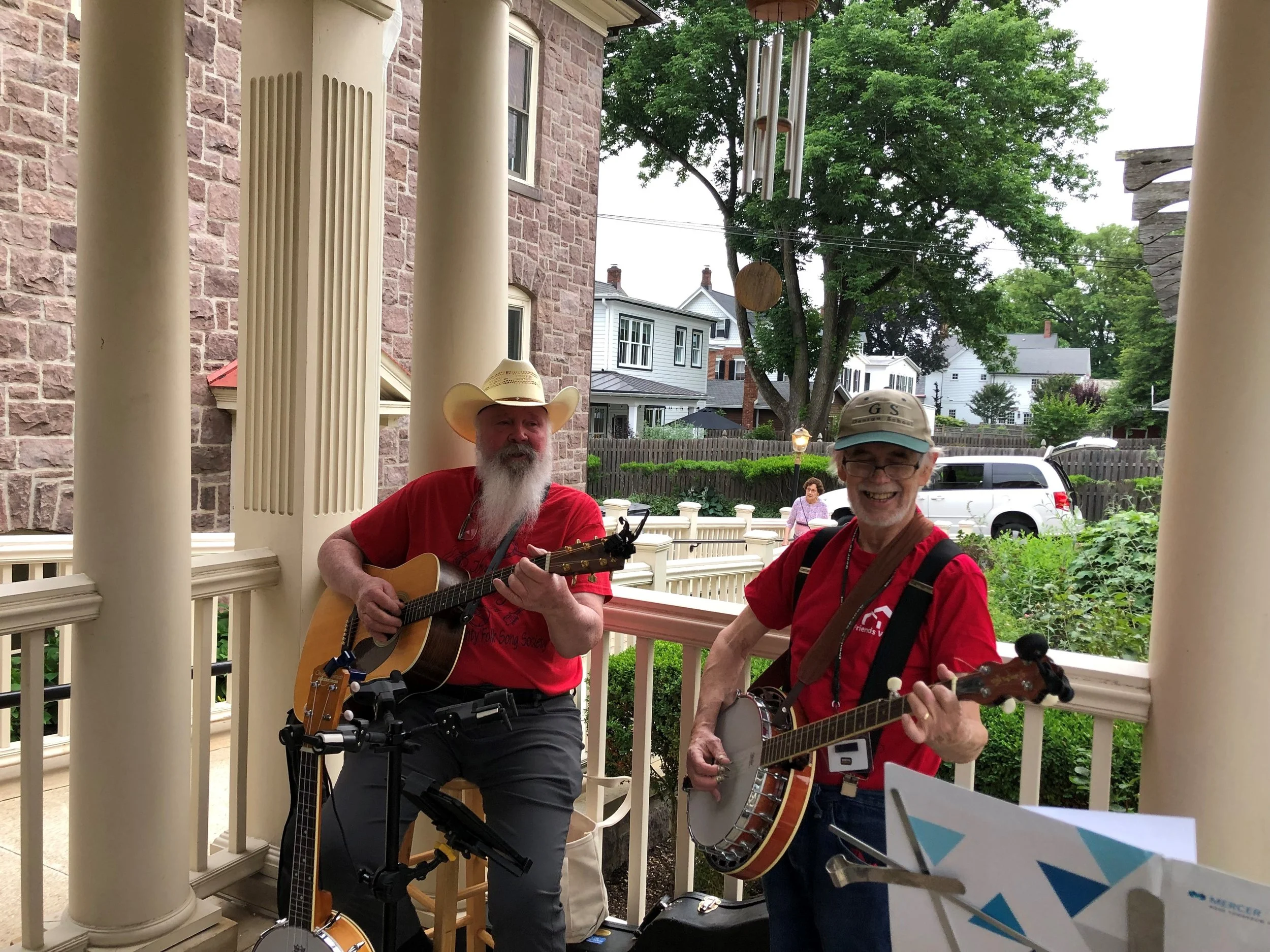 Two musicians performing live on a porch during Newtown Porchfest at Friends Village