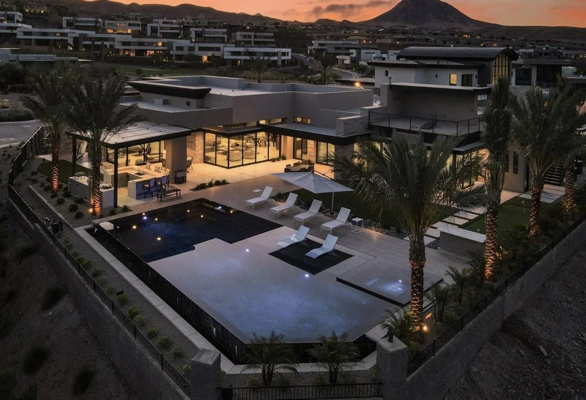 Luxury modern home with swimming pool and palm trees at sunset