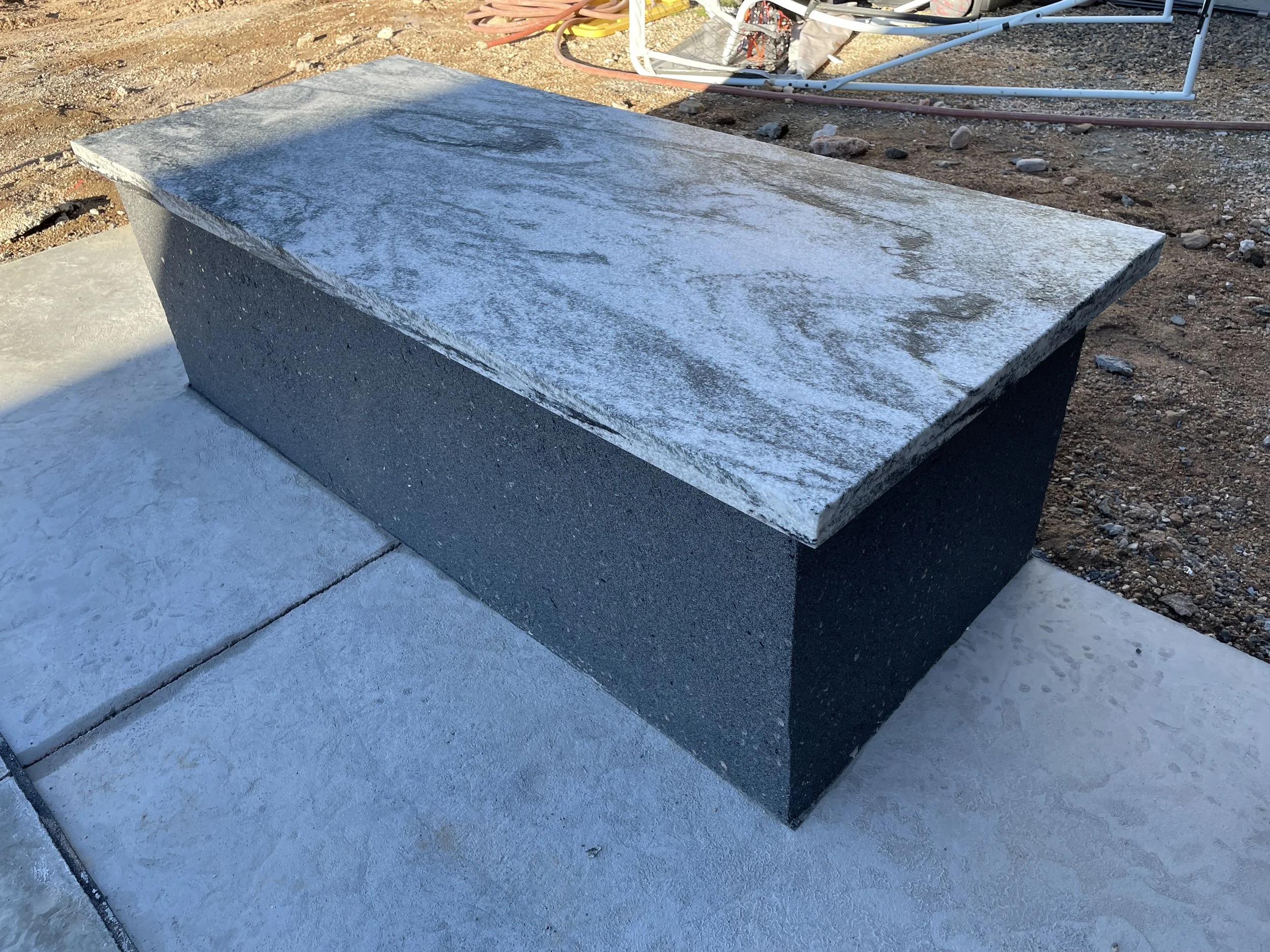 Rectangular stone bench on concrete surface outdoors