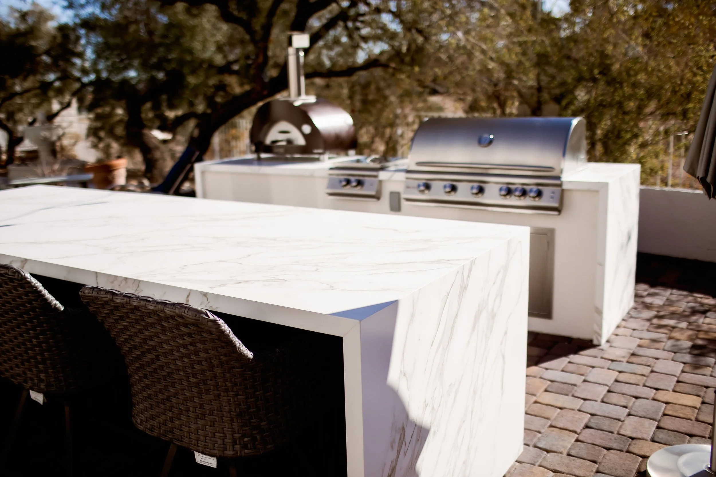 Outdoor kitchen with marble countertop and barbecue grill