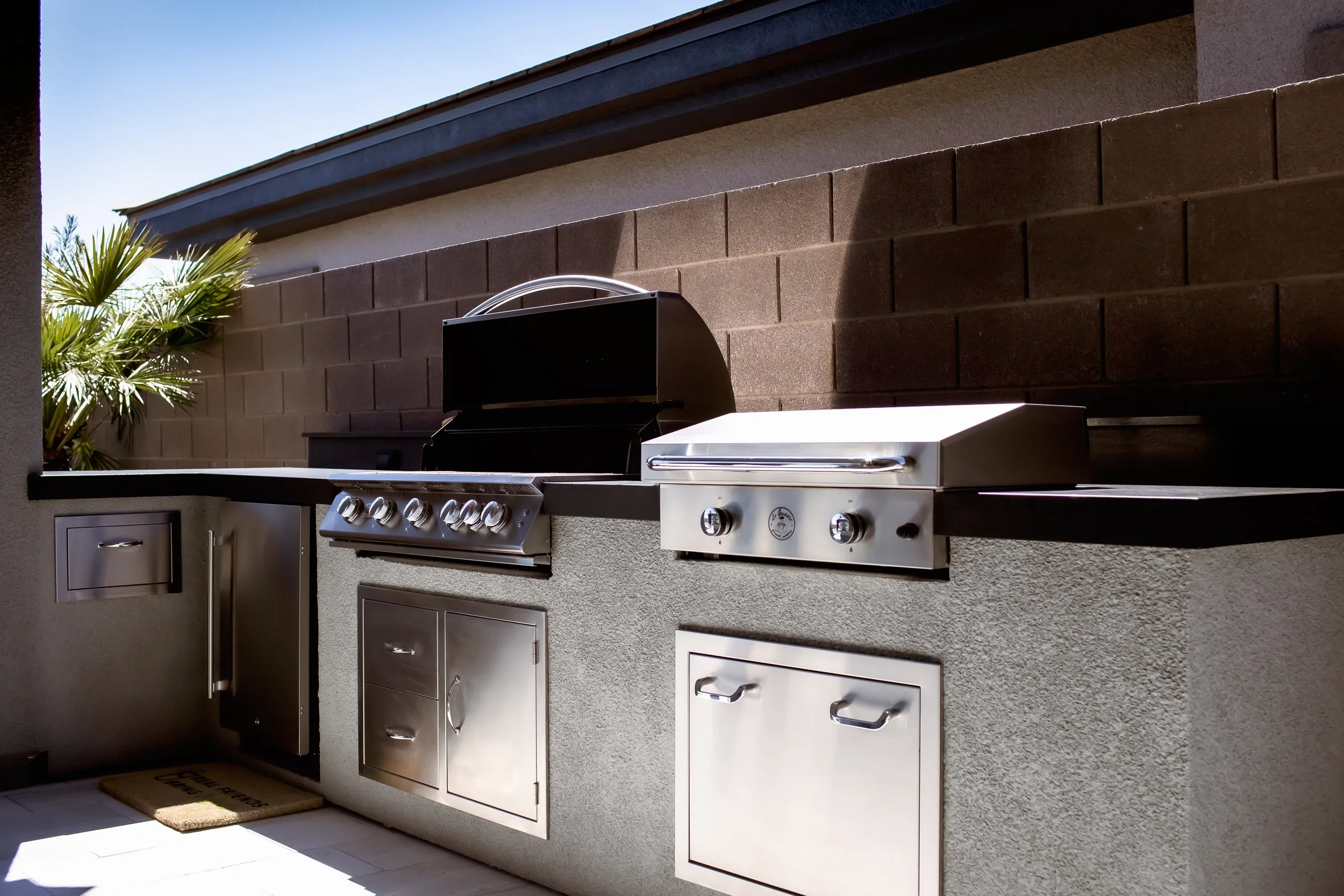 Outdoor kitchen with stainless steel grills and cabinets