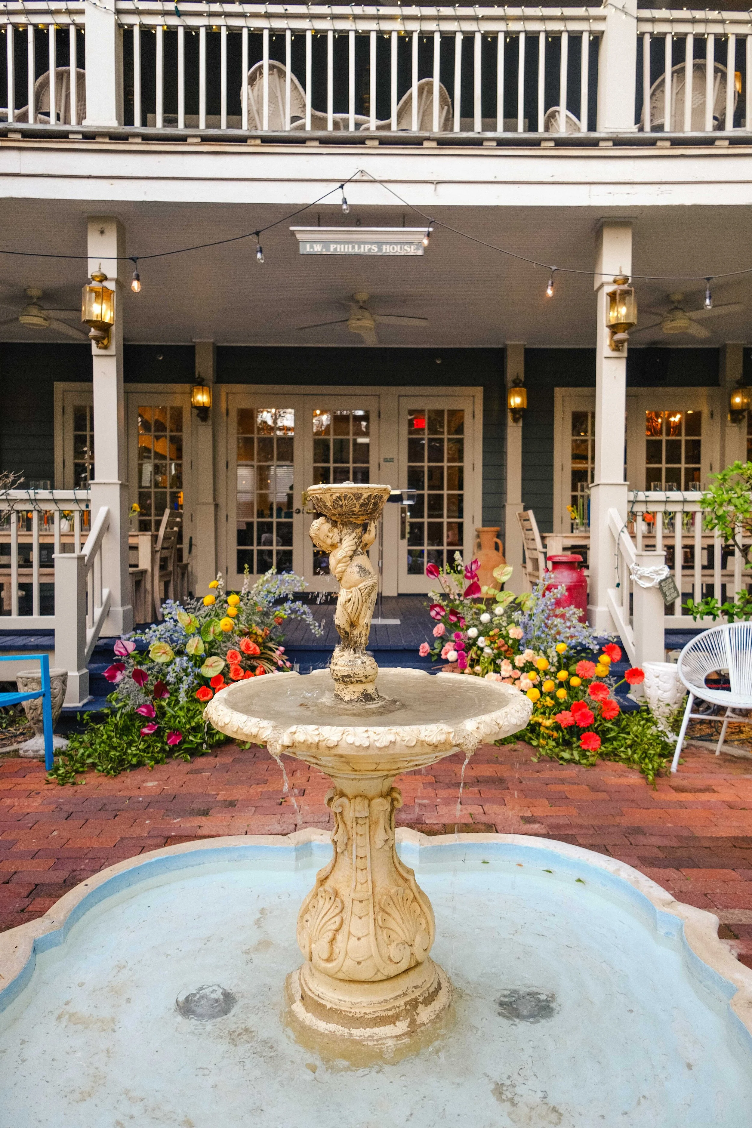 Fountain and flowers in front of a historic house