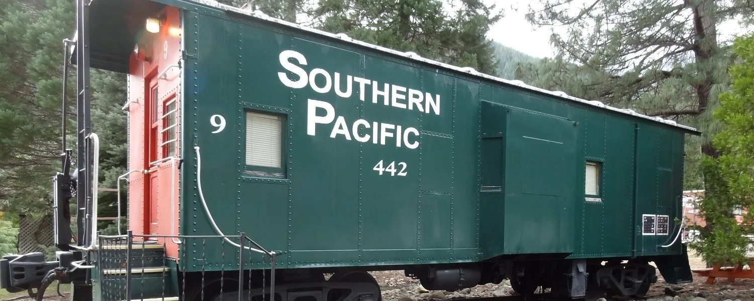 Green and red #9 Southern Pacific caboose exterior with staircase and front door.