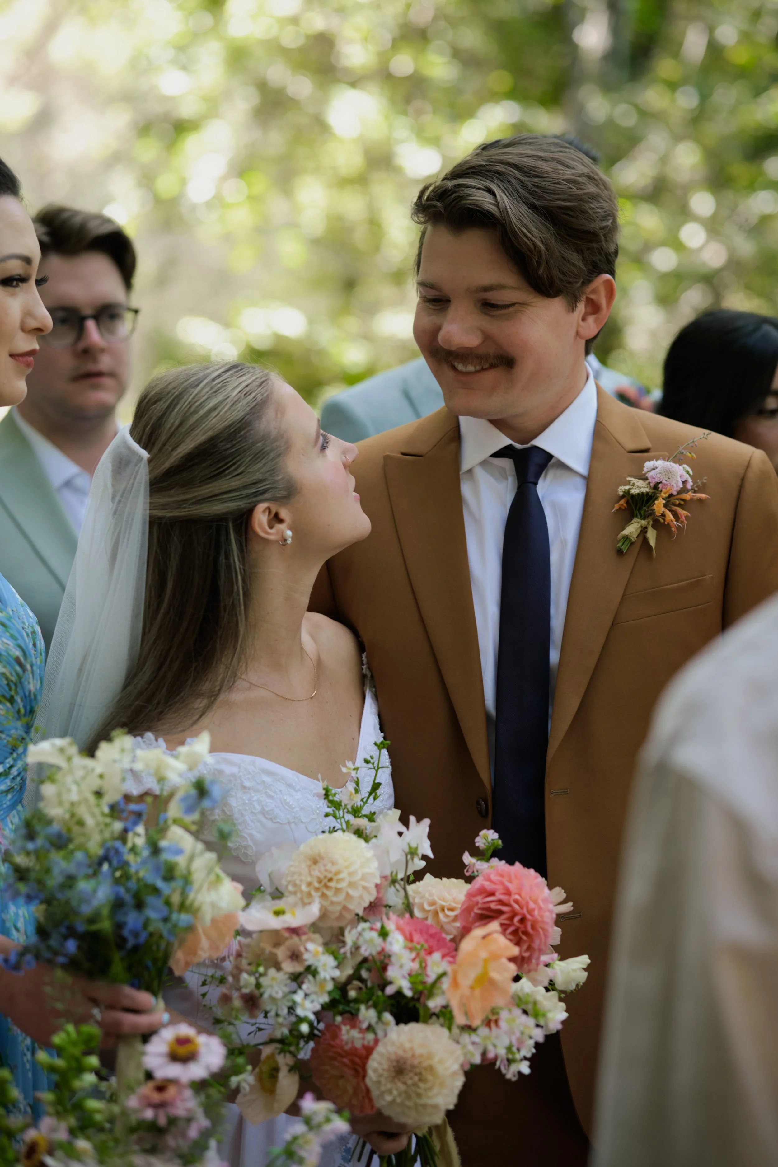intimate moment with bride and groom surrounded by friends 