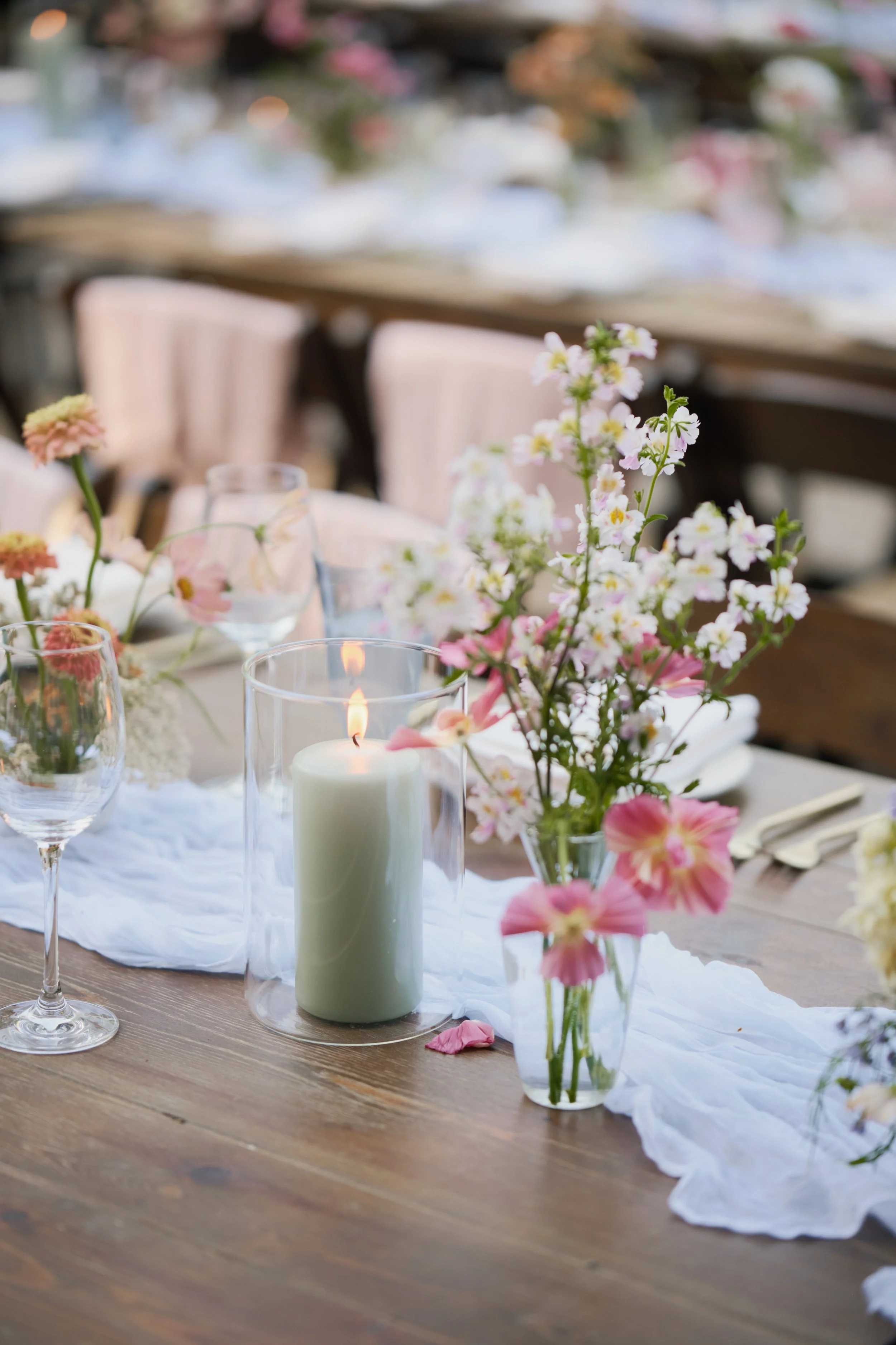 green pillar candles lit with local Santa Cruz summer blooms