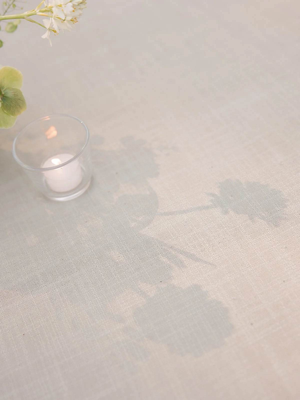 floral shadows and candlelight on reception table