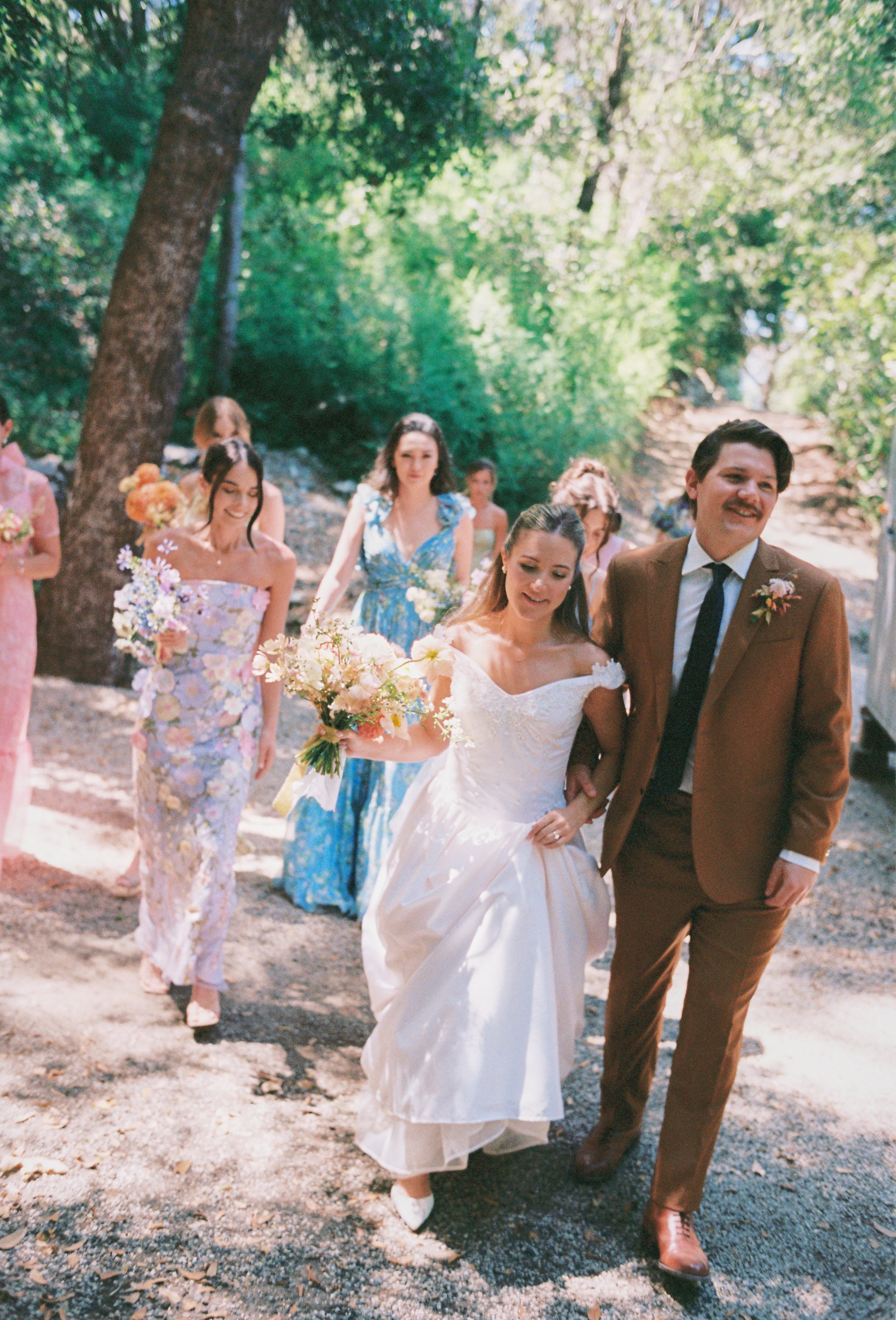 Couple with colorful bridal bouquet walking in the forest
